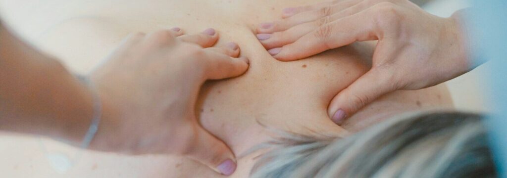 person massaging the back of a woman
